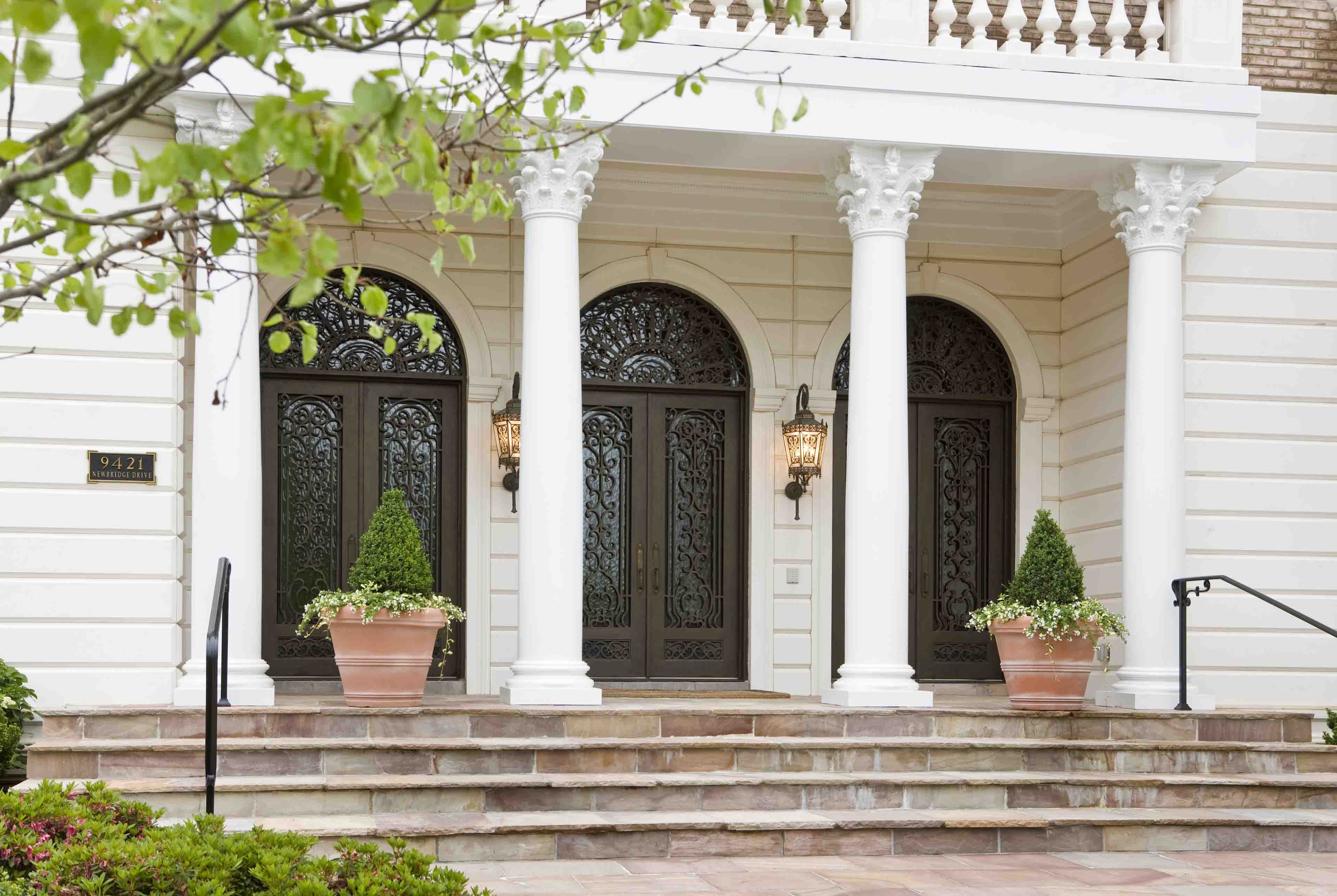 Front entrance with three double doors and columns of a mansion in Potomac, Maryland