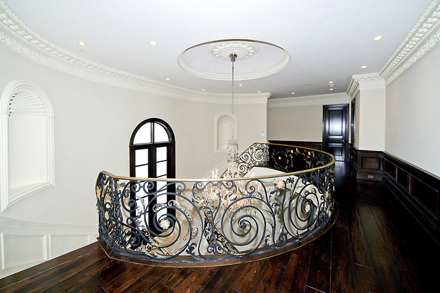 Mansion foyer upstairs staircase with rod iron and gold white custom intricate molding
