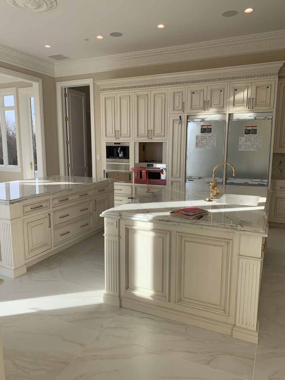 Luxury Kitchen with beige and neutral cabinets, two islands, marble flooring and countertops